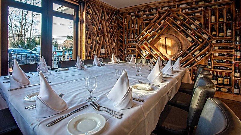 Private dining room with seating for twelve with view of wine case built into wall